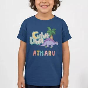 Child wearing navy blue personalized dinosaur birthday T shirt with custom name print in colorful design