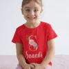 Child wearing red cotton personalized T shirt with floral initial monogram and custom name print