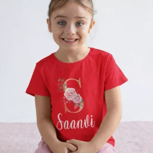 Child wearing red cotton personalized T shirt with floral initial monogram and custom name print