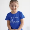 Child wearing blue personalized cotton T shirt with initial and custom name print