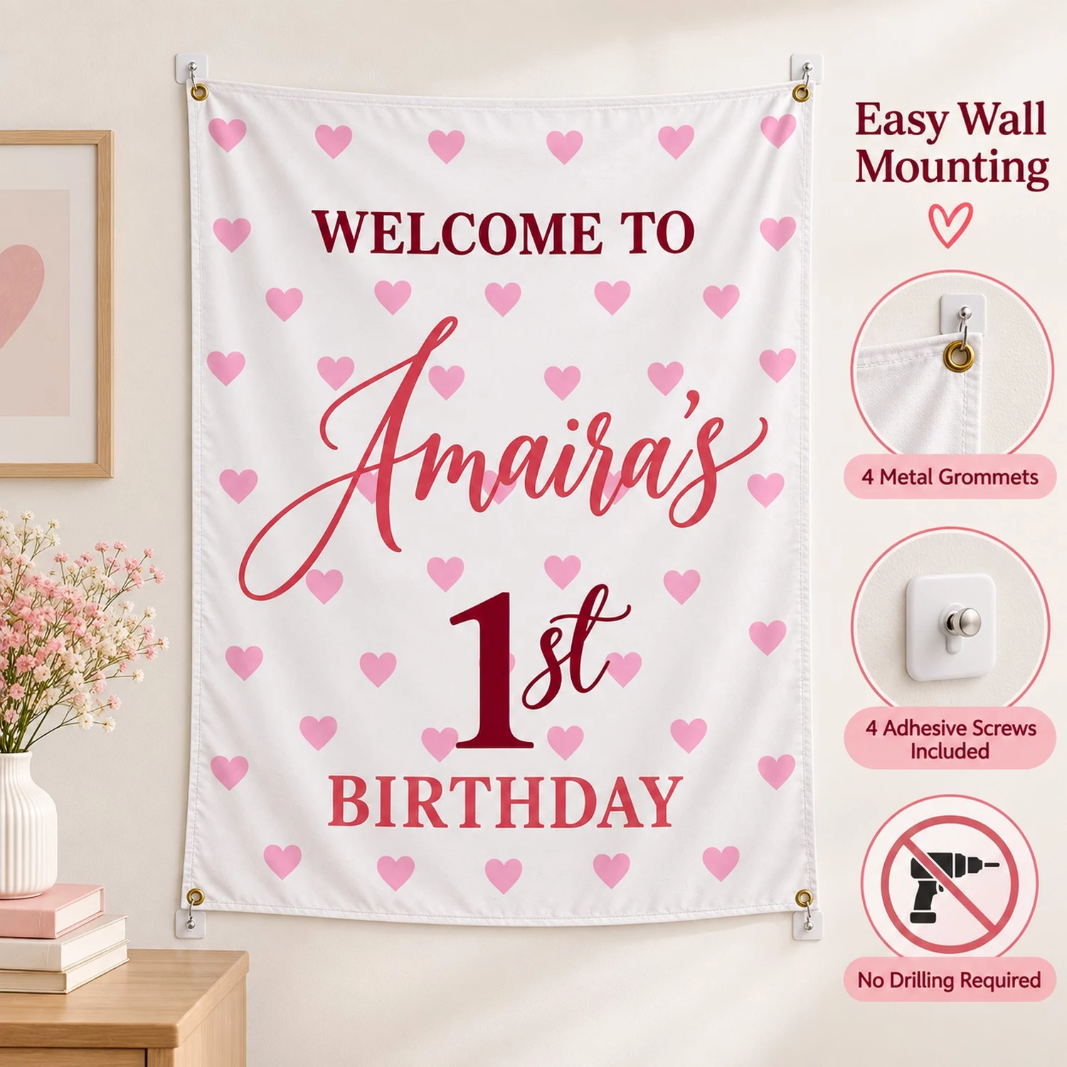 Personalized kids birthday tapestry banner mounted on a wall with four metal grommets and adhesive screws, featuring Amaira’s 1st birthday heart design.