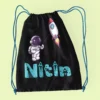 Black cotton drawstring bag with astronaut and rocket design customized with name Nitin