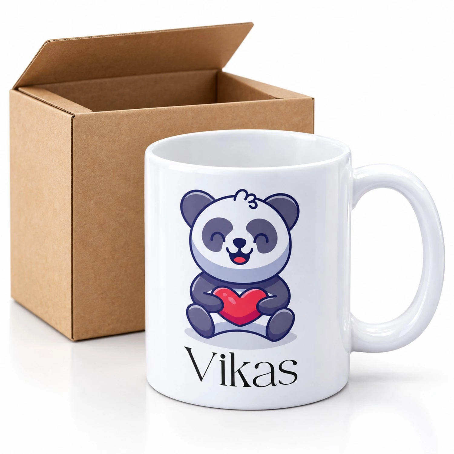 Personalized kids panda coffee mug with the name Vikas displayed beside an open brown packing box.