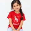Red personalized girls' T-shirt featuring a large gold letter S decorated with pink roses and the name Saanvi in white cursive lettering.