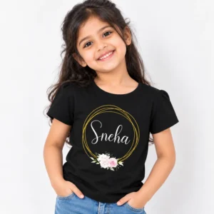 Black personalized girls' T-shirt displaying the name Sneha in white cursive writing inside a gold circular outline with pink and white flowers.