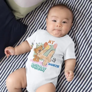 Baby wearing a 4th month birthday milestone onesie with a cute teddy bear design while lying on a bed