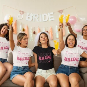 Group of women wearing matching Team Bride t-shirts celebrating a bachelorette party with drinks and decorations