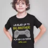 Boy wearing black gaming themed t-shirt with text leveled up to big brother player 2 entering April 2026 for pregnancy announcement