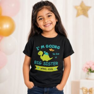 Young girl wearing a black big sister announcement T-shirt with dinosaur design and April 2026 due date text