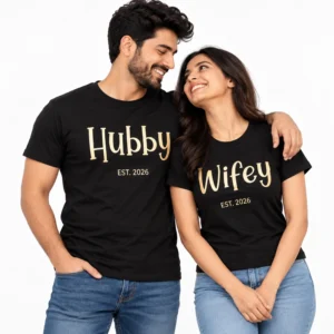 Indian couple wearing matching black Hubby and Wifey T-shirts with large gold-colored typography and EST. 2026 lettering.