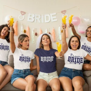 Bride and friends wearing matching bride and team bride t shirts celebrating bachelorette party with drinks and decorations