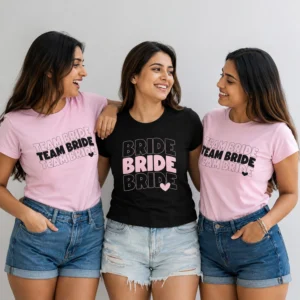 Bride wearing a black Bride T-shirt with friends in matching pink Team Bride T-shirts for a bachelorette celebration