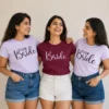 Bride wearing a maroon Bride T-shirt with friends in matching lavender Team Bride T-shirts for a hen party