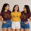 Bride wearing a yellow Bride T-shirt with friends in matching maroon Team Bride shirts for a pre-wedding celebration