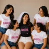 Bride wearing a black stacked Bride T-shirt with friends in matching white and pink Team Bride T-shirts