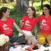 Three women wearing red cousin crew matching t-shirts with tropical design during a picnic outing