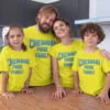 Family of four wearing matching yellow CSK-inspired T-shirts with royal pride typography design for cricket match day