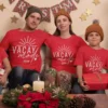 Family wearing matching red vacay mode 2026 t-shirts sitting together during holiday celebration with travel theme