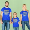 Family wearing matching blue MI Family Squad t-shirts with cricket-inspired design for parents and kids