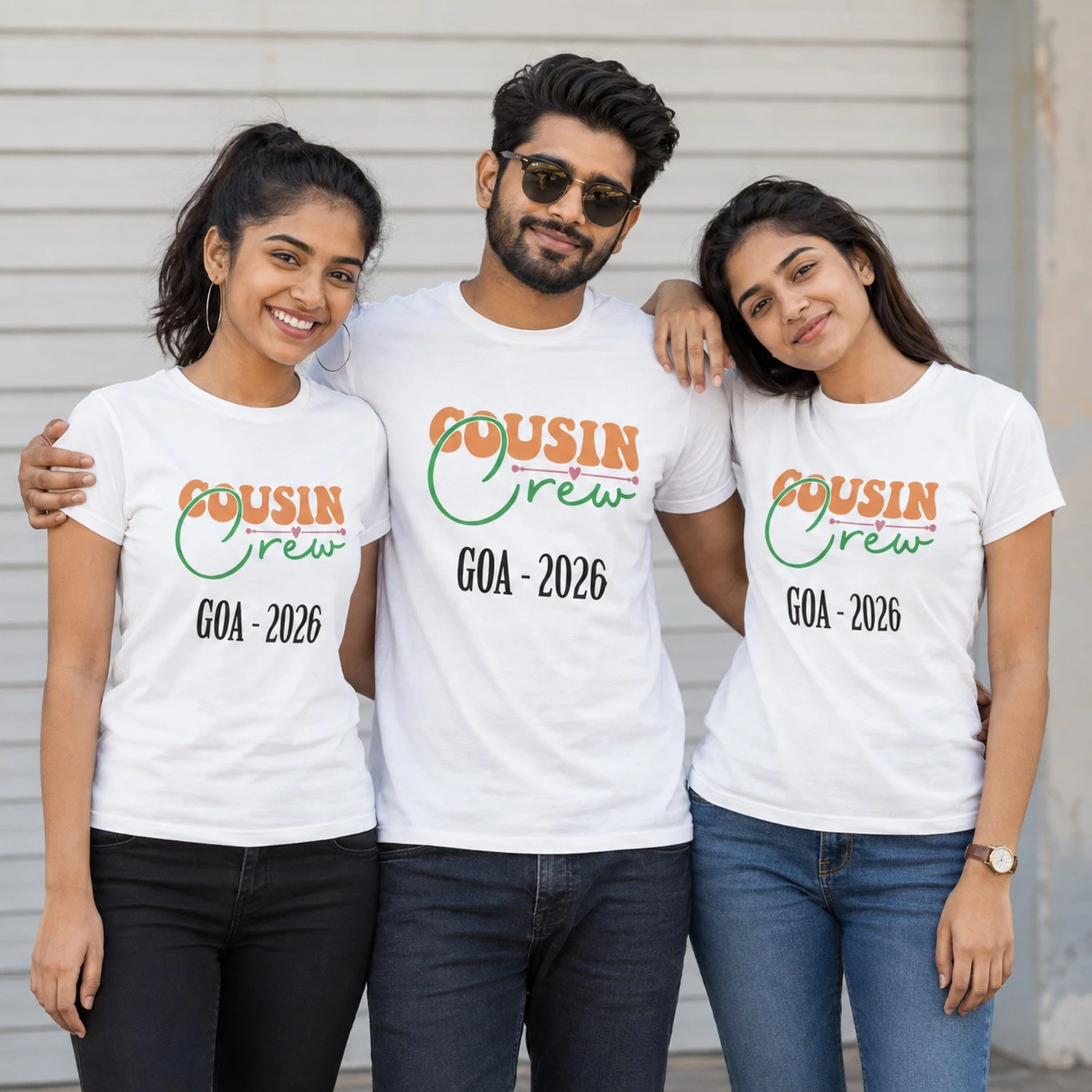 Three cousins wearing personalised white Cousin Crew Goa 2026 T-shirts with orange and green typography