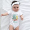 Baby wearing a personalized white onesie with dinosaur design and 1 month milestone text with custom name