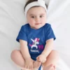 Baby girl wearing a personalized blue unicorn milestone onesie with custom name and 12 months design for photoshoot