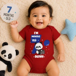 Baby wearing a personalized red milestone onesie with panda design and custom name for monthly photoshoot