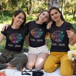 Three women wearing personalized cousin crew Goa trip T-shirts sitting together outdoors, showcasing matching vacation outfits