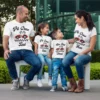 Family wearing personalized pit crew matching t-shirts with names and racing theme design, sitting together outdoors and smiling