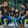 Family wearing personalized vacation mode matching t-shirts with custom name printed, sitting together during a trip