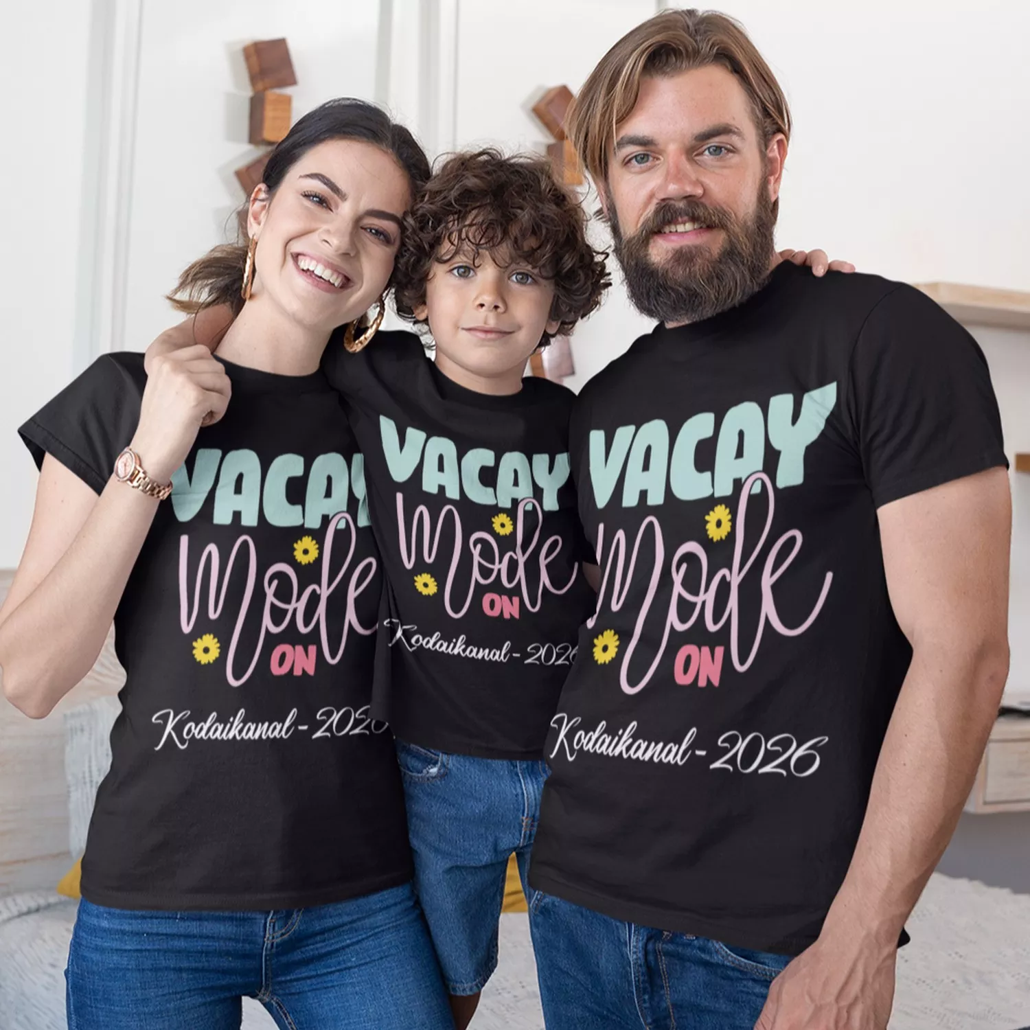 Family wearing matching black vacay mode personalized t-shirts with custom destination text for vacation trip