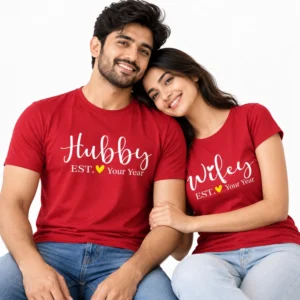 Indian couple wearing matching red Hubby and Wifey T-shirts with white cursive lettering, yellow hearts, and EST. Your Year personalization.