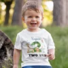 Toddler wearing a personalized jungle theme 2nd birthday T-shirt with name and Two Wild design featuring cute animals
