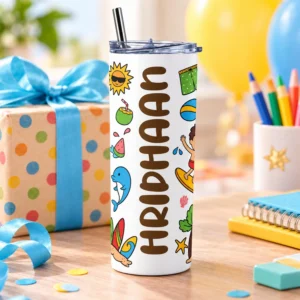 Personalized kids tumbler with RIDHAAN name displayed beside a wrapped gift, ribbon, colorful pencils and notebooks in a cheerful gift setting.
