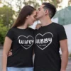 Couple wearing matching black Wifey and Hubby T-shirts with personalized year print in a romantic pose