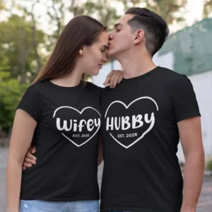 Couple wearing matching black Wifey and Hubby T-shirts with personalized year print in a romantic pose