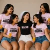 Bride wearing a black Bride T-shirt with friends in matching pink Team Bride shirts at a bachelorette party