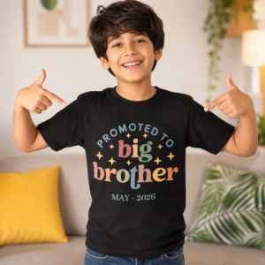 Boy wearing a black promoted to big brother t-shirt holding toys, ideal for pregnancy announcement photoshoot