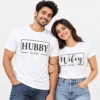 Indian couple wearing matching white Hubby and Wifey T-shirts with black rectangular frame graphics, contrasting lettering, and Est. 2026 text.