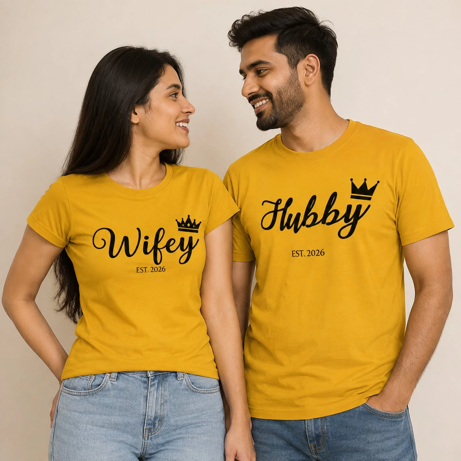 Couple wearing matching yellow Wifey and Hubby Est. 2026 T-shirts with black script lettering and crown graphics