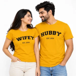 Indian husband and wife wearing matching yellow T-shirts with black outlined varsity-style HUBBY and WIFEY lettering and EST. 2026 text.