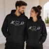 Couple wearing matching black personalized hoodies with initials and a date design, suitable for custom anniversary sweatshirts and matching couple outfits.
