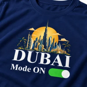 Close-up of a navy blue T-shirt showing the Dubai skyline design with DUBAI text, Mode ON wording, and a green toggle print.