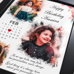 Close-up of a personalized baby birthday photo print showing three-photo artwork, custom name, calendar date and glossy laminated surface.