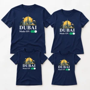 Flat lay of four matching family T-shirts in navy blue with a Dubai skyline print, arranged as adult and kids sizes on a light background.