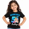 Indian child wearing a black personalized 5th birthday kids t-shirt with a blue mermaid design, "Diving Into 5" text, and the name Aadhya on a light studio background.