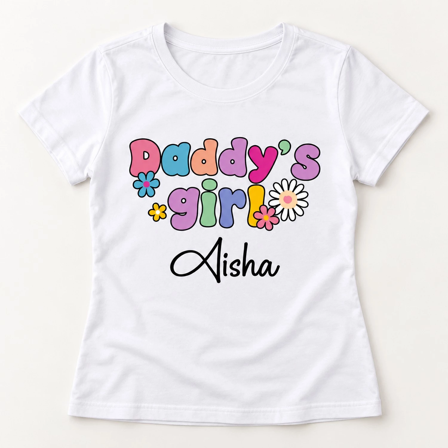 White women's personalized cotton T-shirt laid flat with colorful Daddy's Girl floral lettering and the custom name Aisha printed on the front.