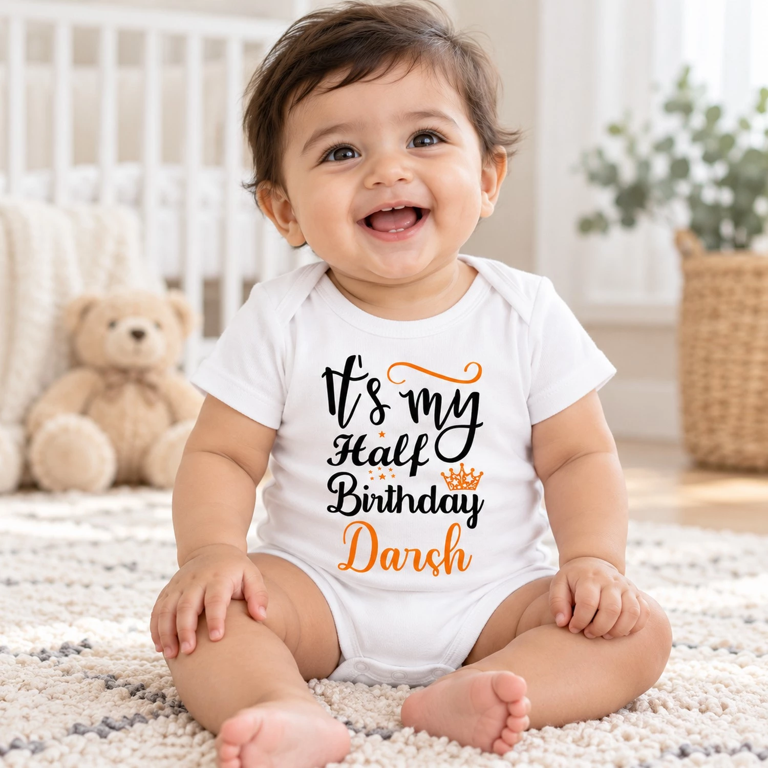 Happy baby wearing a white personalized half birthday baby romper with Darsh name while sitting in a bright neutral nursery.