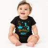 Baby wearing a black personalized half birthday baby romper with turquoise and gold “It’s My 1/2 Birthday VICKY” crown and star design.