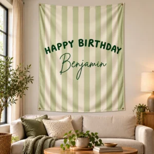 Large personalized kids birthday tapestry with sage and cream stripes and Benjamin name displayed above a neutral sofa in a bright living room.